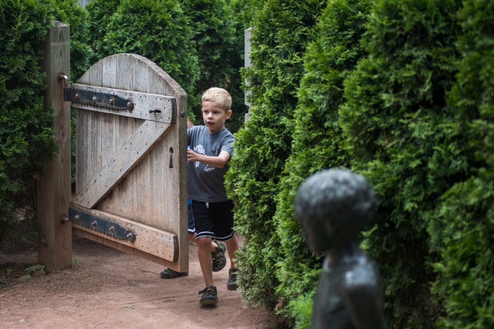 Dimondale, Mich. resident Brody Looney, 6, pushes his way through a door June 28, 2016 at the 4-H Children's Garden. The 4-H Children's Garden's mission is to teach children about plants and the role they play in society, to nurture a child's imagination and curiosity and to provide a place of enrichment and delight for children of all ages.