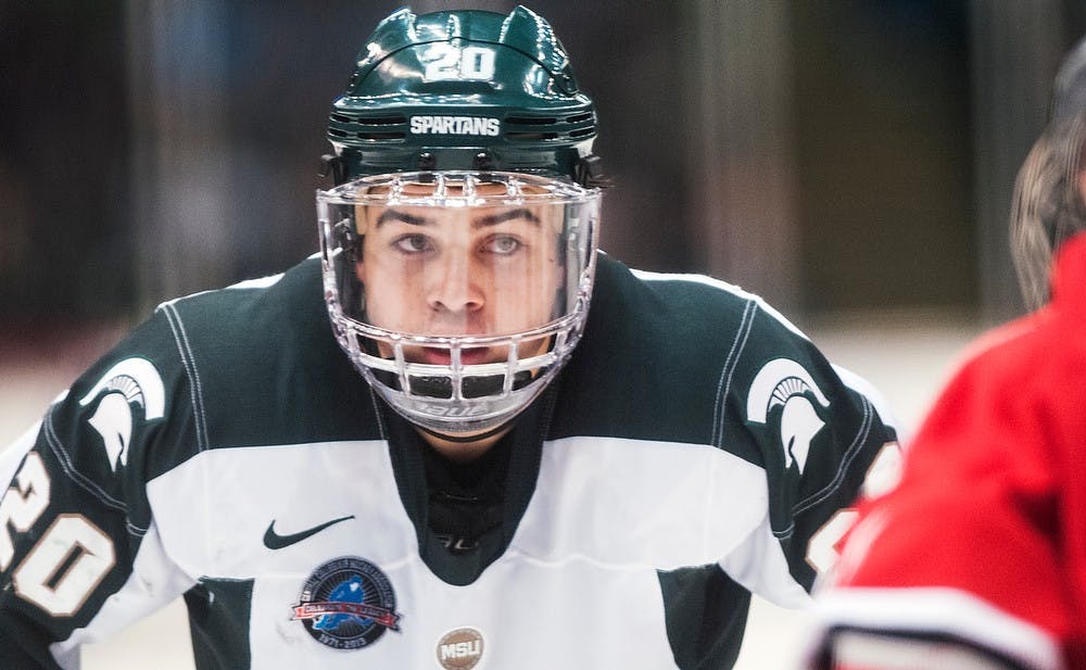 	<p>Freshman center Michael Ferrantino looks at a Buckeye player before a face-off Friday night, Nov. 30, 2012, at Munn Ice Arena. The Ohio State Buckeyes defeated the Spartans, 1-0, with a late goal in the third period. Adam Toolin/The State News</p>