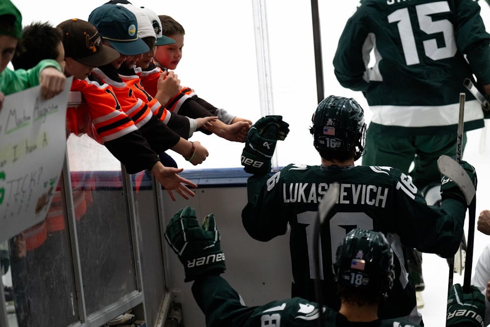 <p>Michigan State playershi-five fans while taking the ice against the under-18 U.S. Men's National Team Development Program at USA Hockey Arena in Plymouth, Michigan on Nov. 21, 2024. In front of a sold out crowd, the Spartans captured a convincing 6-2 victory, showcasing why they deserve their ranking of number two in the nation.</p>