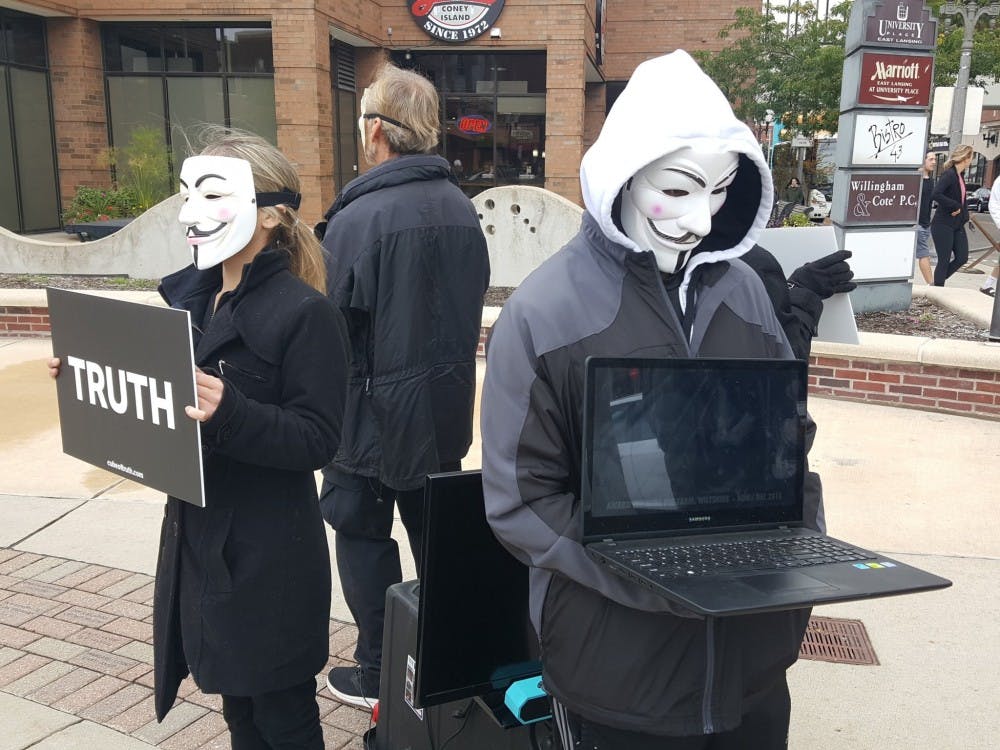 Members of Anonymous for the Voiceless, an animal rights and welfare organization, form a "cube of truth" outside of the East Lansing Marriott on Sunday, October 29 2017. 
