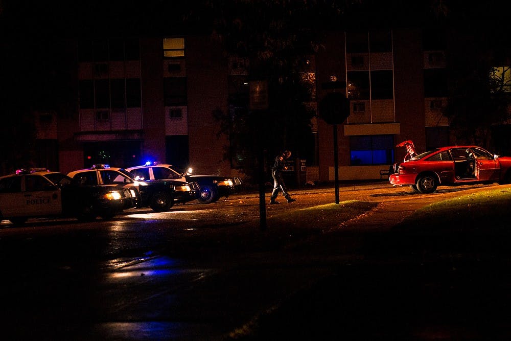 <p>Police officers respond to a shots fired complaint Oct. 18, 2014, on Abbot Road near Fern Street. Erin Hampton/The State News</p>