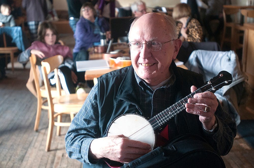 <p>East Lansing resident and MSU alumnus Jim Levande, 76, plays his banjolele, a cross between a banjo and ukulele, March 7, 2015, during a PT Strummers performance at Sir Pizza, 201 E. Grand River Ave. in Lansing. Levande started playing the ukulele in 2013 in a beginner's class put on by East Lansing's Prime Time Seniors' Program. Kelsey Feldpausch/The State News </p>