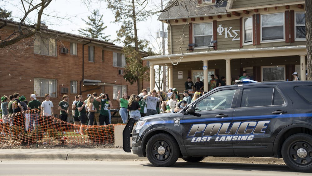 <p>An East Lansing police car sits outside of a fraternity house as students celebrate St. Patrick’s Day in East Lansing. Shot on March 17, 2022.</p>