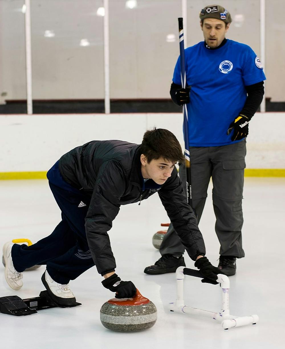 	<p>Vice president of the Lansing Curling Club Wyl McCully instructs Stockbridge resident Alan Baird on his curling technique during the Olympic Curling Open House on Feb. 23, 2014, at The Summit Sports and Ice Complex. Casey Hull/The State News</p>