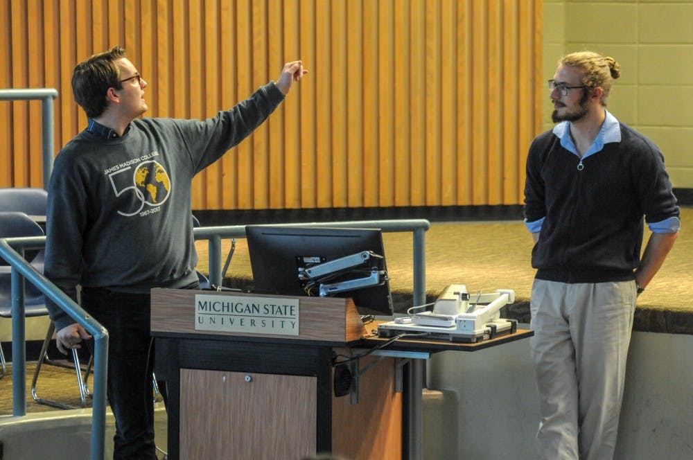 James Madison senior Walter Hanley, left, and Roosevelt Institute sophomore Perry Truscon, right speaks at the Lift the Rock: Spartans for Accountable Investment Agenda at Erickson Kiva on April 18, 2019.