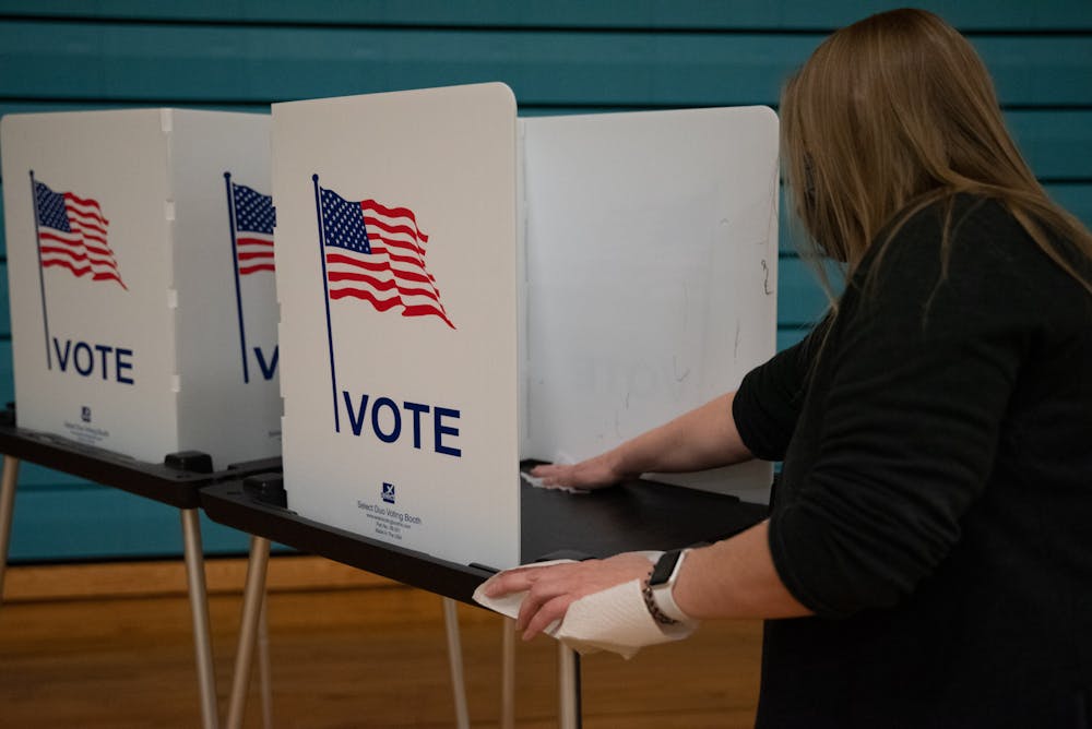 <p>Southside Community Center poll vounteer sanitizing voting sations on Tuesday, November 3, 2020.</p>