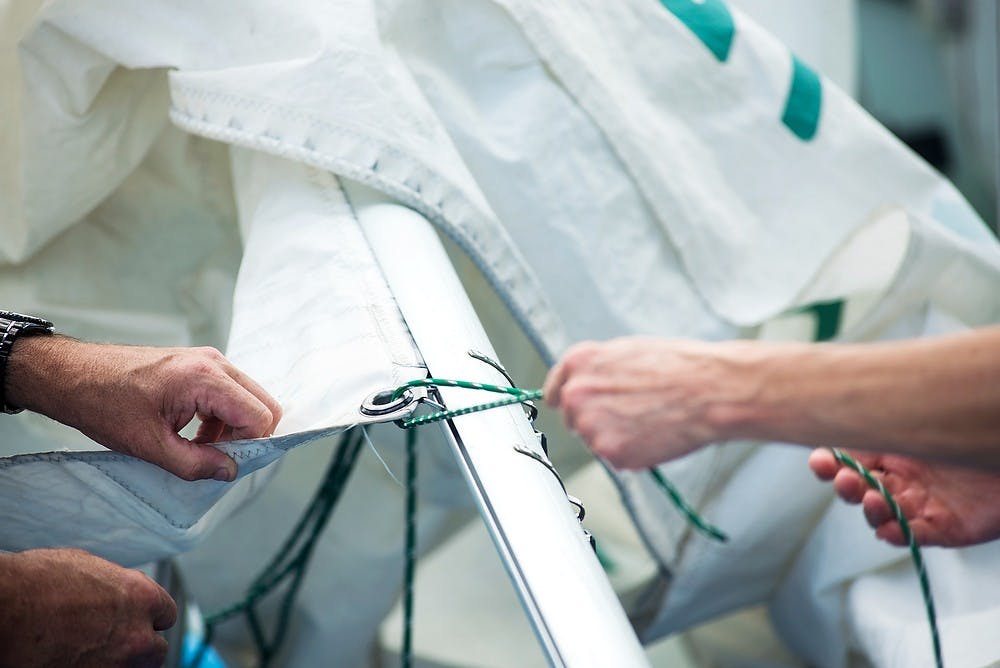 <p>From left, Lansing resident Gary Bush and Portland, MIich., resident Chris Flaga prepare a boat for sail June 26, 2014, at the Sailing Center off the shore of Lake Lansing. Flaga and Bush were both grateful for the windy day on the last day of class. Hayden Fennoy/The State News</p>