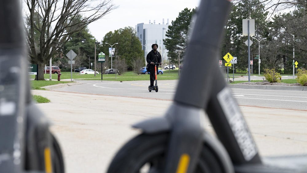 Person riding a Spin scooter in the East Neighborhood at Michigan State University campus on April 14, 2025