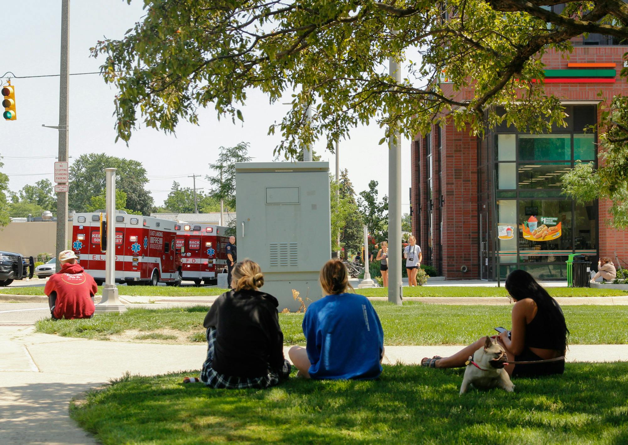 <p>Hub residents, including Sydney Hodges (middle), Riley Modlin (right) and her dog Frankie, find shade as they wait to be allowed back into the building. &quot;I&#x27;m honestly just really confused, they don&#x27;t tell us anything,&quot; Hodges said. Image was taken just outside of the Hub on July 26, 2021.</p>