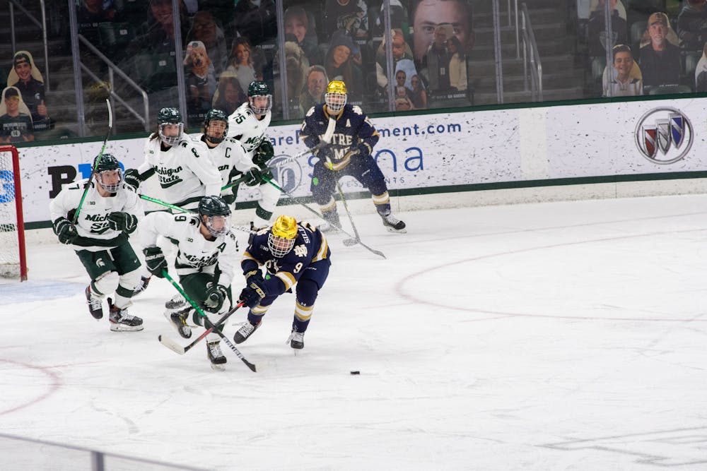 <p>The Spartans and Notre Dame&#x27;s Grant Silianoff (9) rush towards the puck in Michigan State&#x27;s loss to Notre Dame on Feb. 26, 2021.</p>