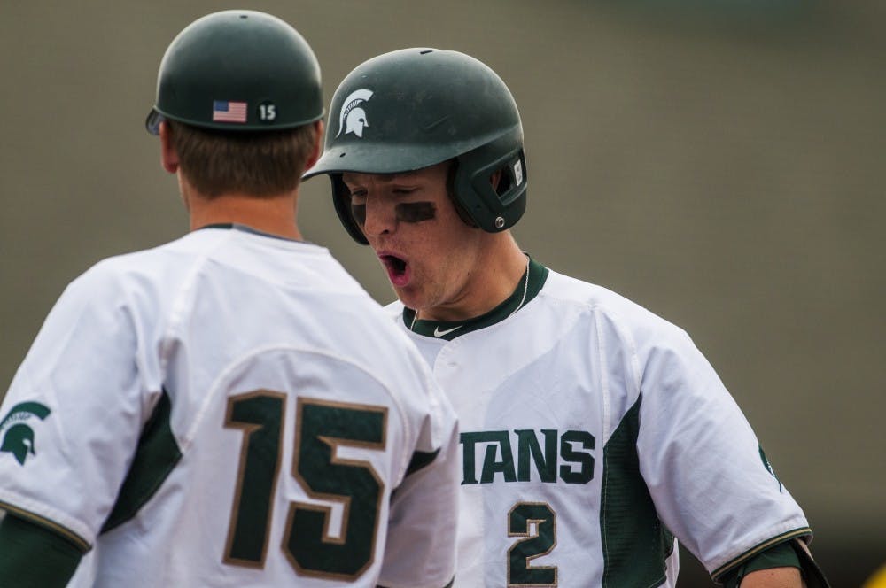Volunteer assistant coach Jordan Keur talks to freshman infielder Marty Beachina during the game against Michigan on April 30, 2016 at McLane Stadium. The Spartans defeated the Wolverines, 7-6. 