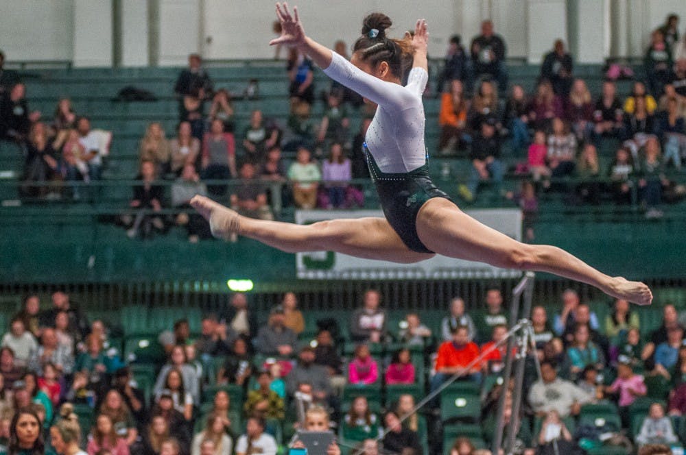 Senior Anna Gamelo performs a split leap during her beam routine at the event against Illinois on Feb. 17, 2018 at Jenison Fieldhouse. 