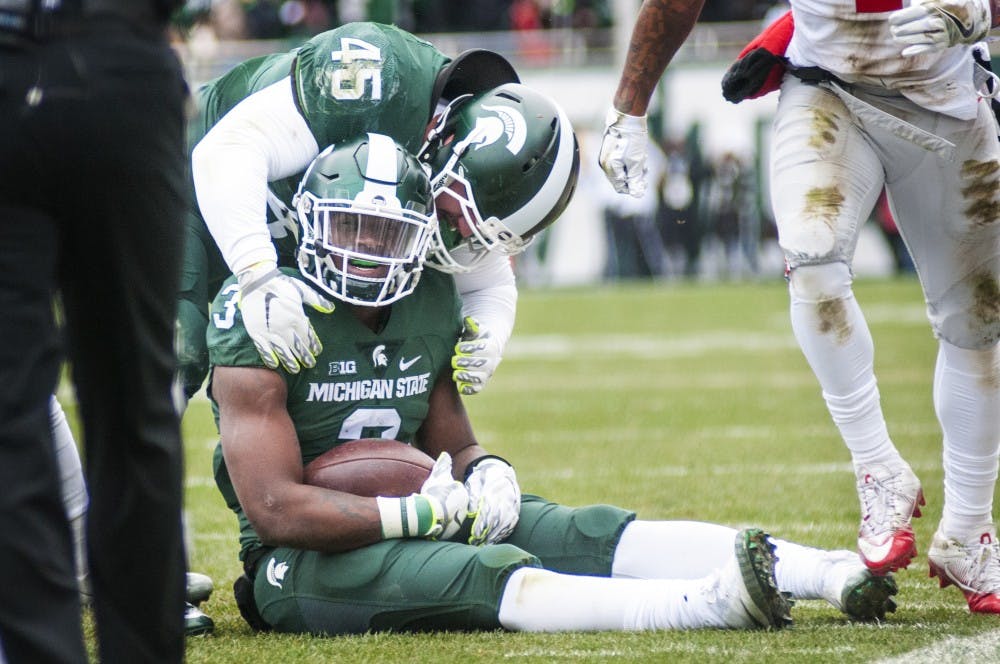 Senior fullback Prescott Line (45) shares a moment with sophomore running back LJ Scott (3) during the first half of the game against Ohio State on Nov. 19, 2016 at Spartan Stadium. The Spartans were defeated by the Buckeyes, 17-16.