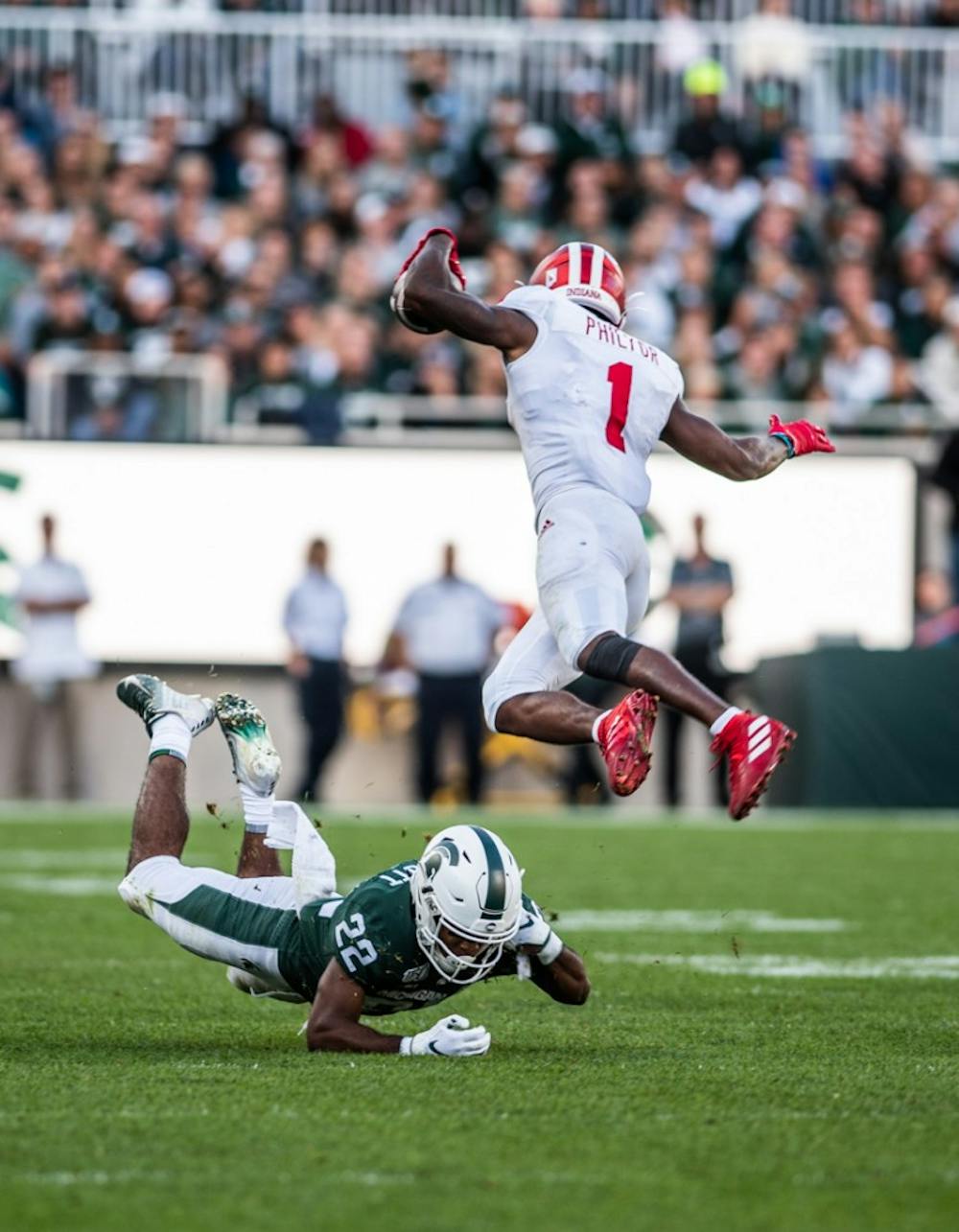 <p>Junior center back Josiah Scott (22) dives under Indiana wide receiver Whop Philyor (1) during the homecoming game against Indiana on Sept. 28, 2019, at Spartan Stadium. The Spartans beat the Hoosiers, 40-31.</p>