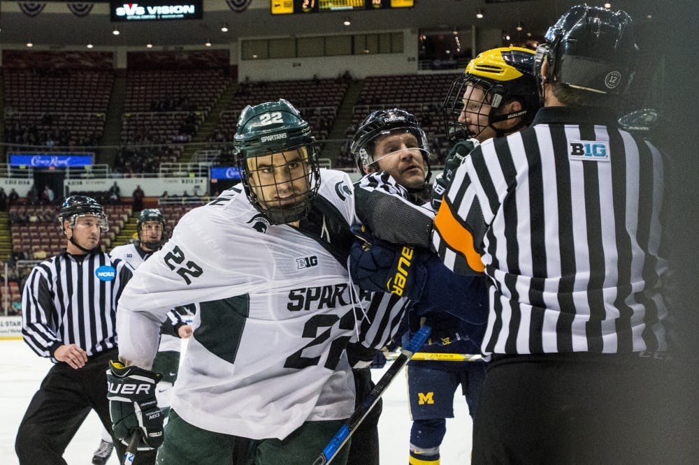 Senior wingman JT Stenglein (22) has his jersey tugged on during the second period of the 52nd Annual Great Lakes Invitational third-place game against the University of Michigan on Dec. 30, 2016 at Joe Louis Arena in Detroit. The Spartans were defeated by the Wolverines in overtime, 5-4.