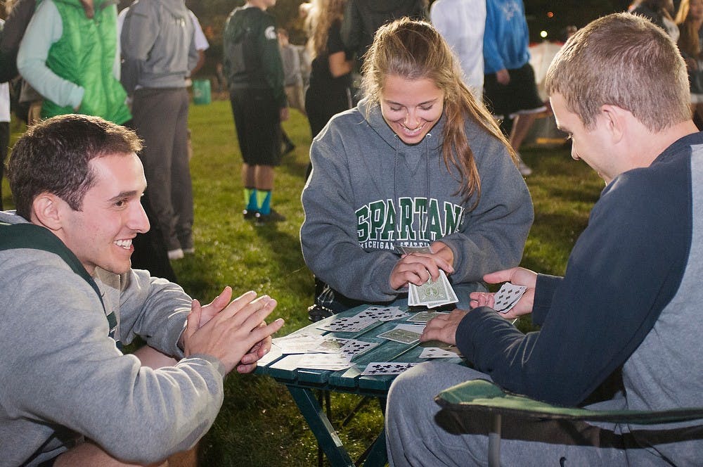 	<p>Economics junior Seth Bursky, left, elementary education senior Ali Sanchez, middle, and kinesiology senior Eric Shultz play the rummy card game on Sept. 27, 2013, at Munn Intramural Field during the Izzone campout. This was the third campout for Shultz and Bursky and first for Sanchez. Georgina De Moya/The State News </p>