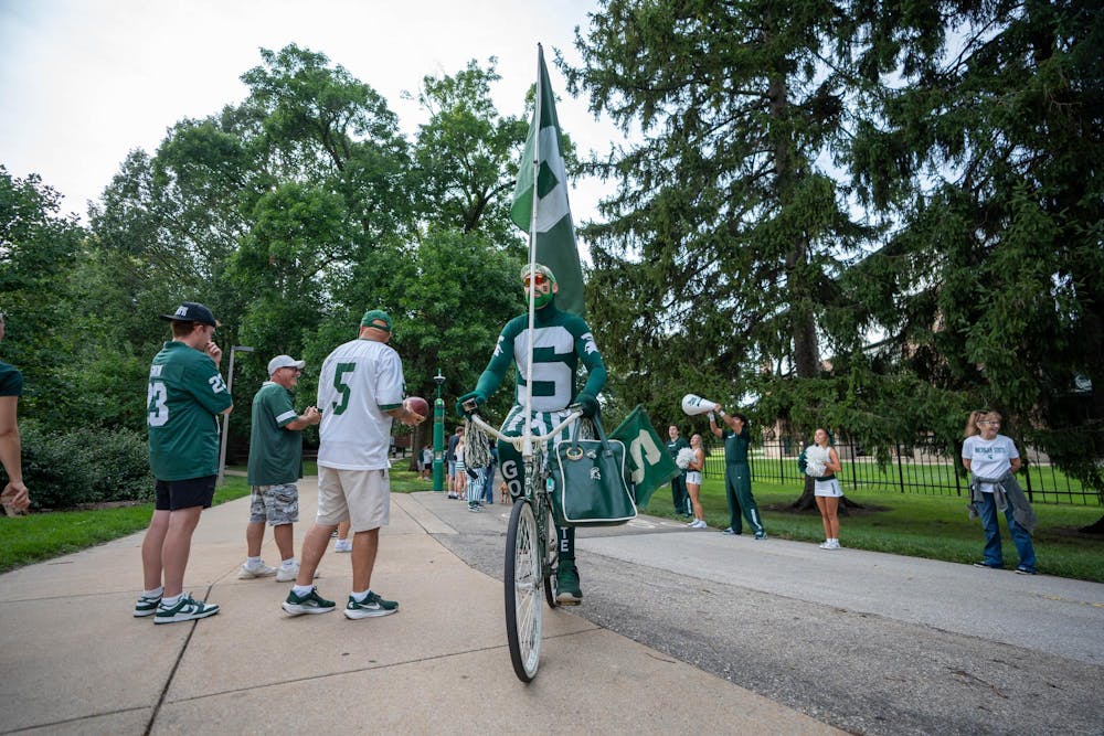 Johnny Spirit rides a bike before the Michigan State vs. Toledo football game at Spartan Stadium in East Lansing, Mich., on Friday, Sept. 4, 2026.