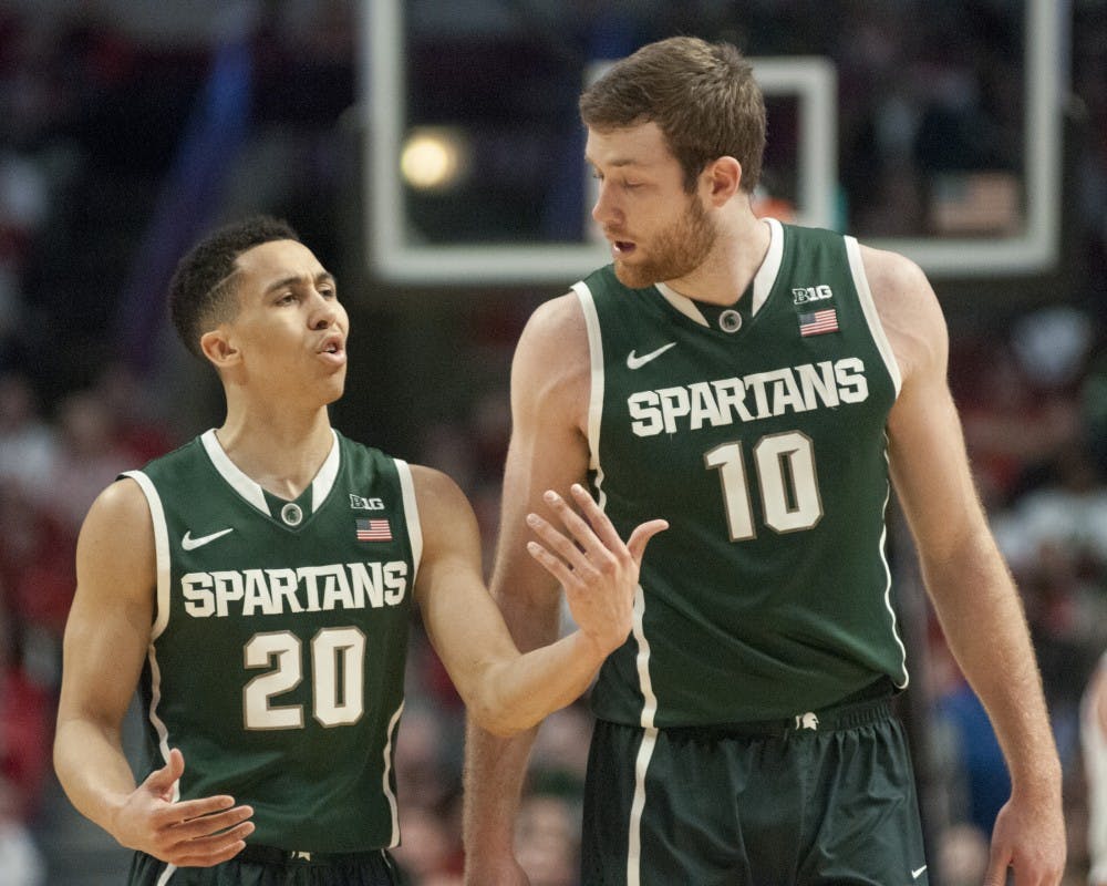 <p>Senior guard Travis Trice and junior forward Matt Costello make their way off the court Mar. 15, 2015, during a timeout in the championship game of the Big Ten Tournament against Wisconsin at United Center in Chicago. The Badgers defeated the Spartans in overtime, 80-69. Kelsey Feldpausch/The State News</p>