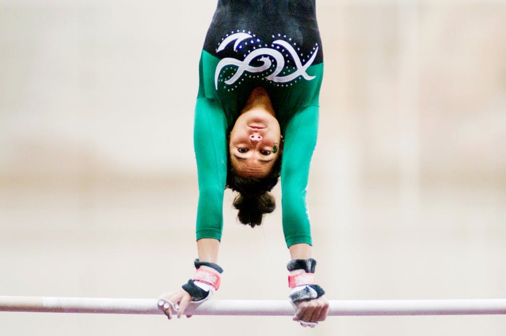 Senior Selina Rodriguez keeps herself vertical while performing at the uneven bars event. The Michigan State Spartans felt to Washington Huskies, 193.175-191.875, Friday night at Jenison Field House. Justin Wan/The State News