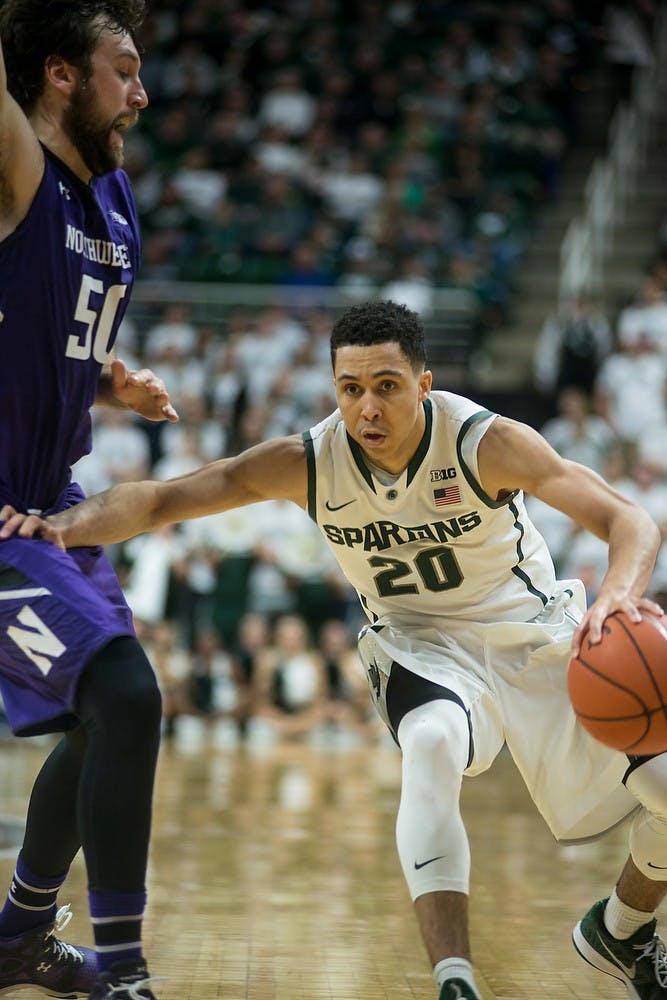 <p>Senior guard Travis Trice breaks away from Northwestern center Jeremiah Kreisberg Jan. 11, 2015, during the game at Breslin Center. At halftime, the Spartans were tied with the Wildcats, 40-40. Erin Hampton/The State News</p>