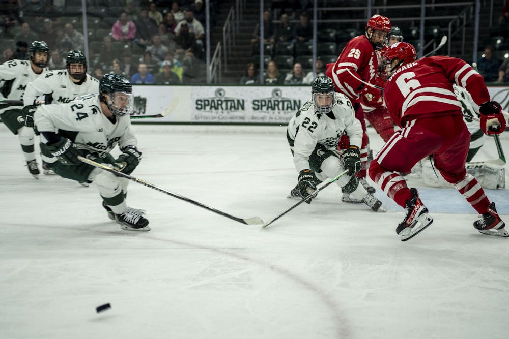 <p>Senior forward Erik Middendorf (24) chases after the puck during a game of ice hockey between MSU and Wisconsin at Munn Ice Arena on Nov. 4, 2022. The Spartans won, 5-0. Middendorf scored four of the goals.</p>