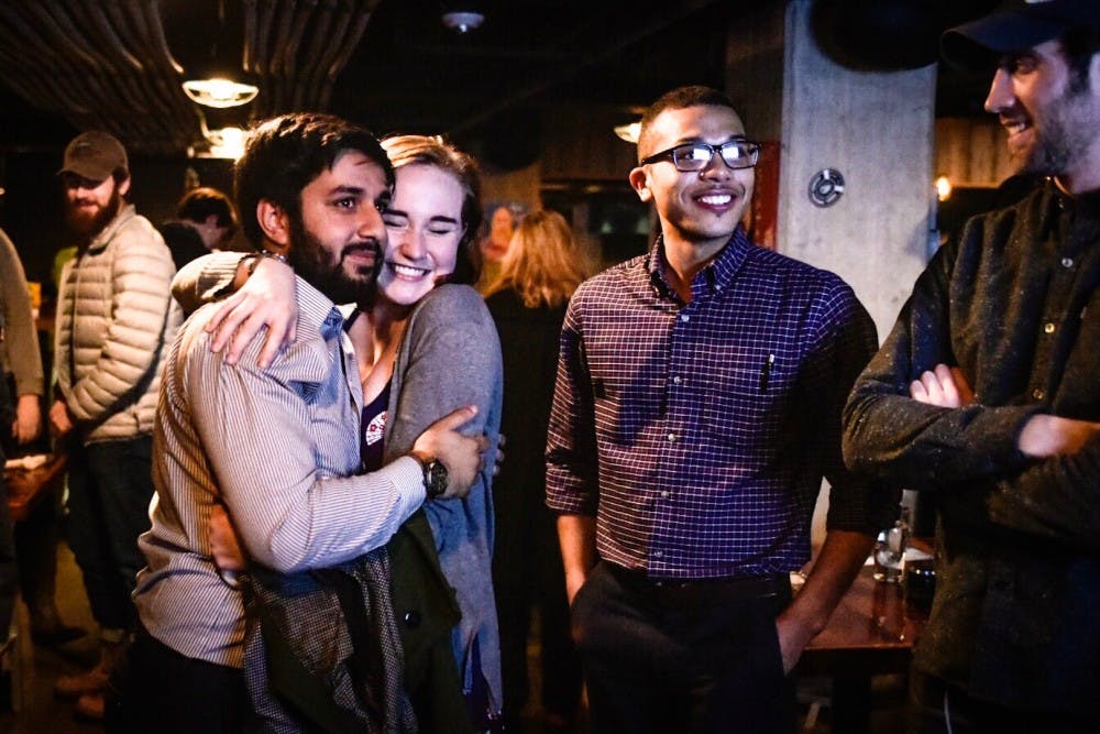 <p>Political science senior Aaron Stephens, left, and international relations junior Natalie Smith react to the victory of Aaron Stephens for East Lansing City Council on Nov. 7, 2017 at Hopcat.&nbsp;</p>