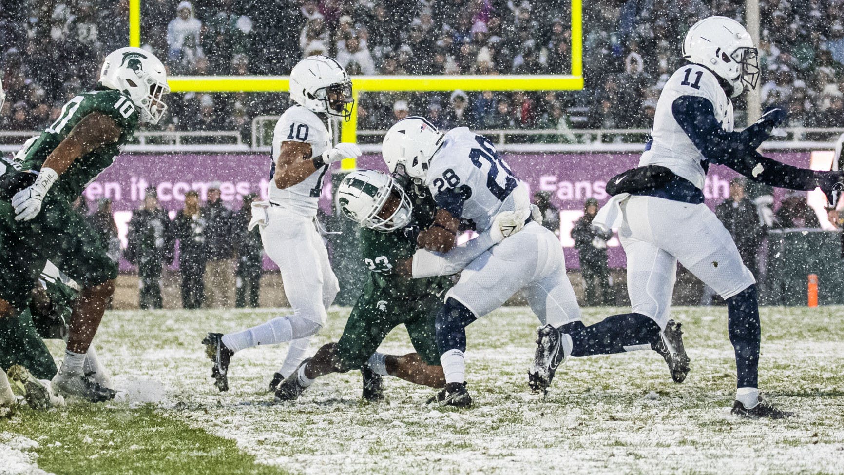 <p>Sophomore safety Darius Snow (23) tackles Penn State's junior running back Devyn Ford (28) in MSU's match against the Nittany Lions at Spartan Stadium on Saturday, Nov. 27, 2021.</p>