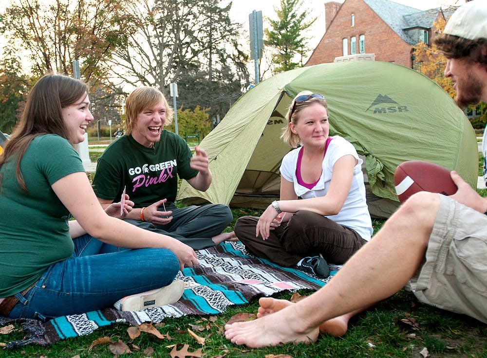From left, animal science sophomore Anne Meyers, social relations and policy senior Austin Muir, James Madison sophomore Kristi Schmidt, and natural resource recreation and tourism senior Luke Miller camp out Wednesday, Oct. 24, 2012, in a field between Yakeley and Landon Hall. The students were participating in an event coordinated by Muir to raise funds for the American Cancer Society in support for Breast Cancer Awareness. James Ristau/The State News