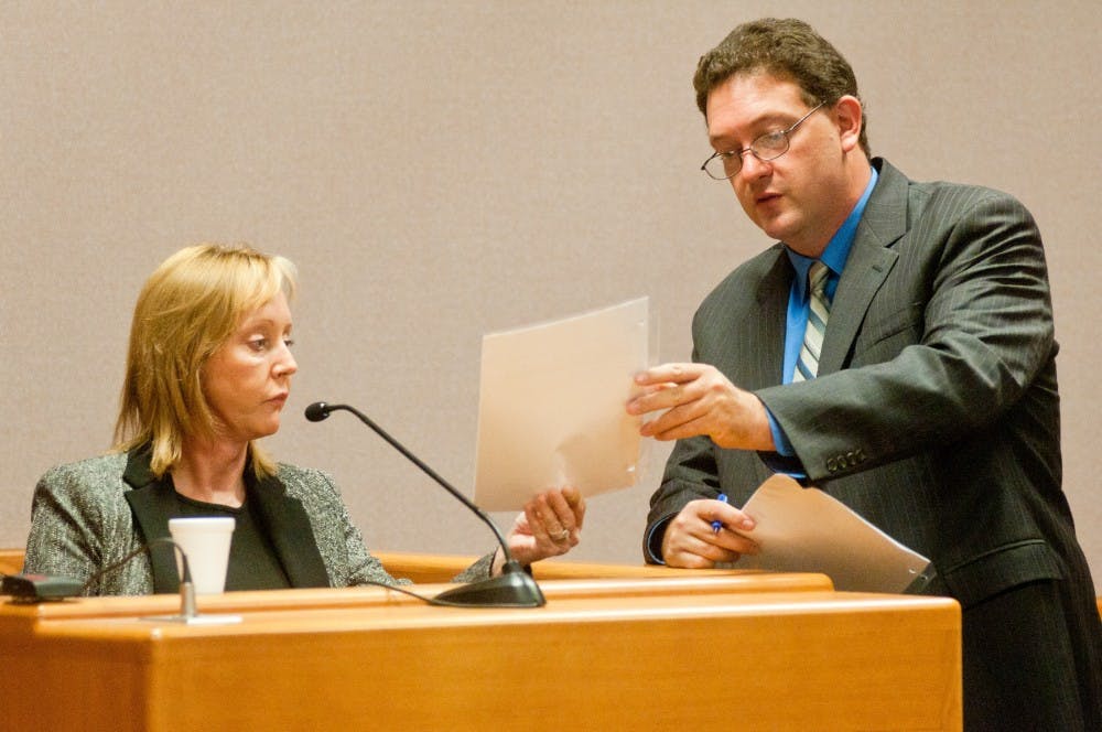Ingham County Assistant Prosecutor Bill Crino hands Joyce DeJong, the medical director of forensic pathology at Sparrow Hospital, a copy of MSU freshman Olivia Pryor's autopsy report during a preliminary examination on Tuesday, Aug. 21, 2012. DeJong, who is an Ingham County medical examiner, revealed the results of her autopsy during her testimony. Julia Nagy/The State News