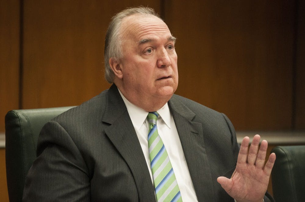 <p>Interim President John Engler lets survivor Kaylee Lorincz know her time to speak is up during the Board of Trustees meeting on April 13, 2018 at Hannah Administration Building. (C.J. Weiss | The State News)</p>