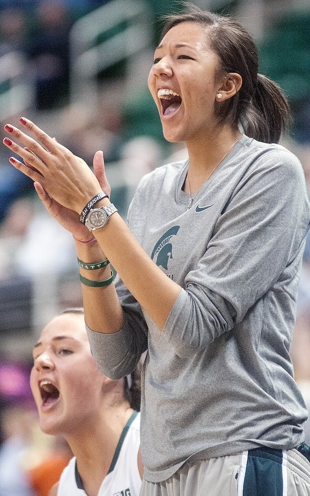 Sophomore center Madison Williams cheers from the bench after a shot is made Nov. 4, 2012, at Breslin Center. The women's basketball team defeated Grand Valley State 83-36 in the second and final exhibition game of the season. Adam Toolin/The State News