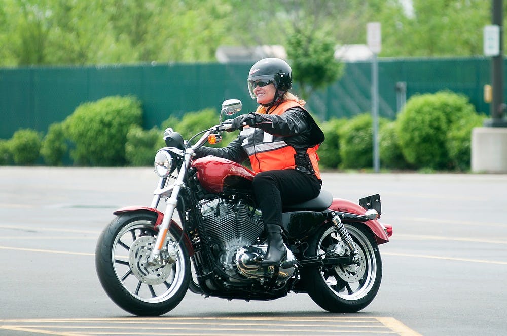 	<p>Michigan Secretary of State Ruth Johnson rides a motorcycle May 21, 2013, in a parking lot of Lansing Community College West Campus motorcycle safety range. Johnson was speaking in order to promote the use of high visibility gear, helmets and motorcycle safety awareness. Danyelle Morrow/The State News</p>