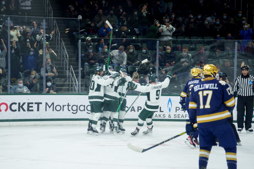 <p>Michigan State fifth-year senior Mitchell Lewandowski joins in on celebrating with junior forward Erik Middendorf after he scores the first goal of the game on Feb. 18, 2022. Spartans lost 2-1 against Notre Dame.</p>