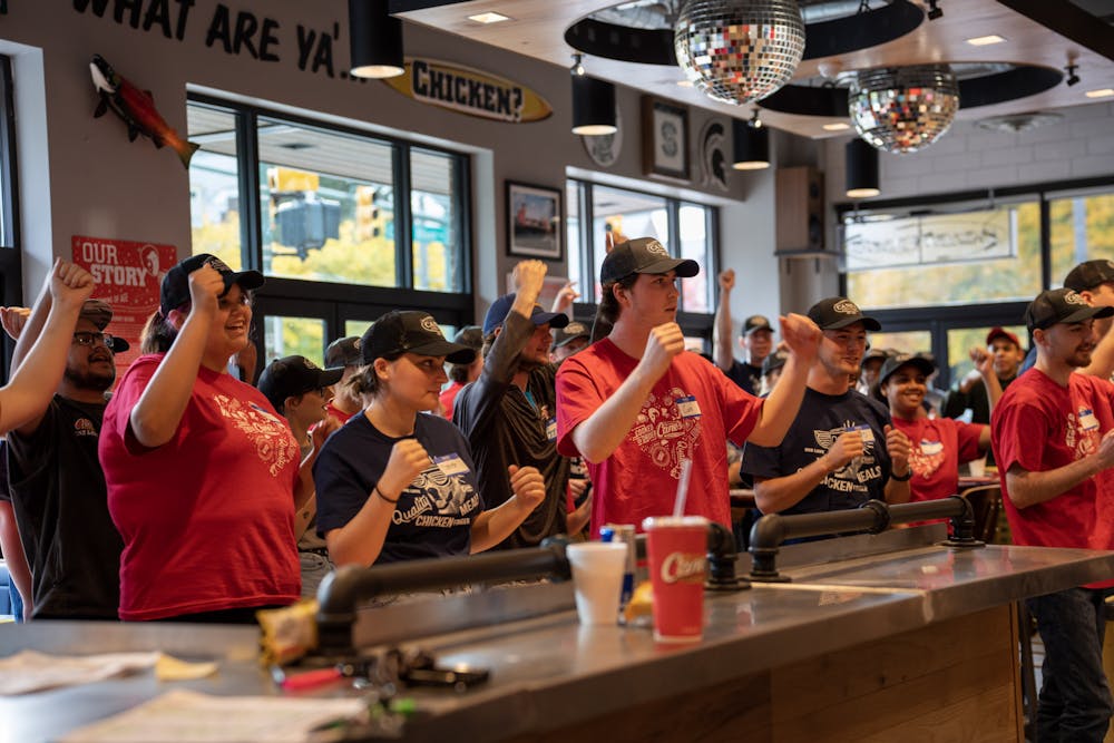 <p>Raising Canes crew chants as they get ready for the grand opening of the location located off of Grand River on Oct. 14, 2022. </p>