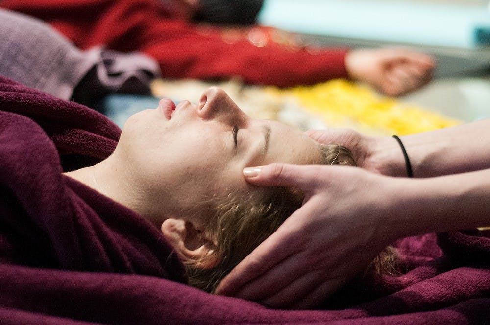	<p>Yoga teacher Sloane Montgomery holds international relations senior Ashley Kukuk&#8217;s head during a yoga session Jan. 25, 2013, at the Eli and Edythe Broad Art Museum. Montgomery encouraged those at the session to interact with props, such as blankets and pillows. </p>