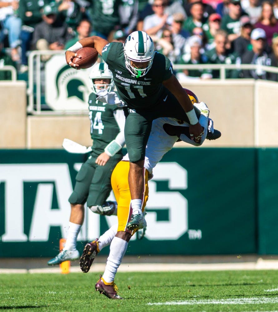 Sophomore running back Connor Heyward (11) jumps over Central Michigan players during the game against Central Michigan at Spartan Stadium on Sept. 29, 2018. The Spartans defeated the Chippewas 31-20.