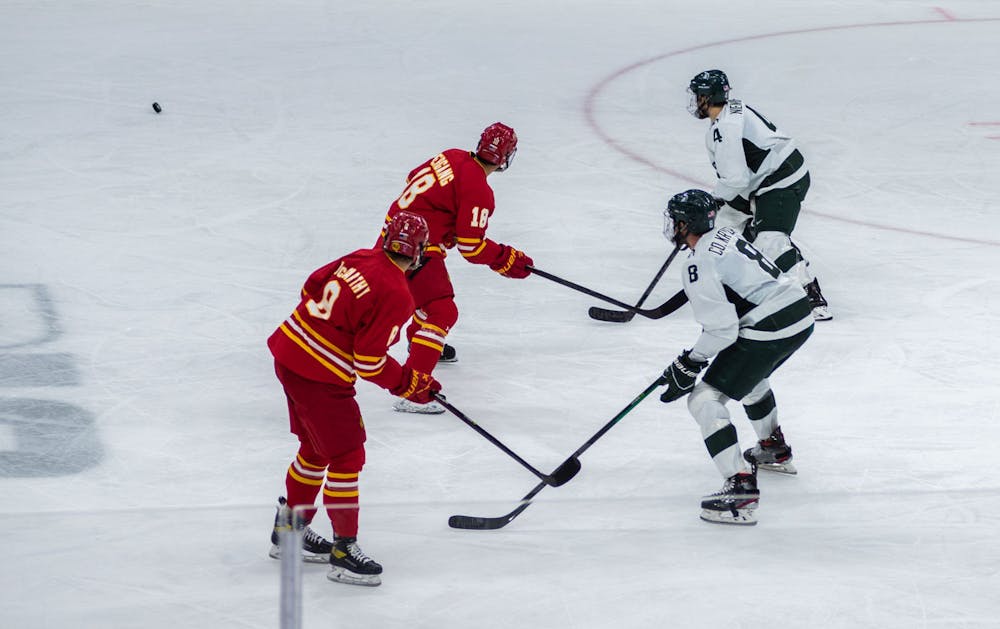 <p>Michigan State and Ferris State players stare down a loose puck during the second period. The Spartans beat the Bulldogs, 2-0, in the final minutes of the game on Nov. 11, 2021. </p>