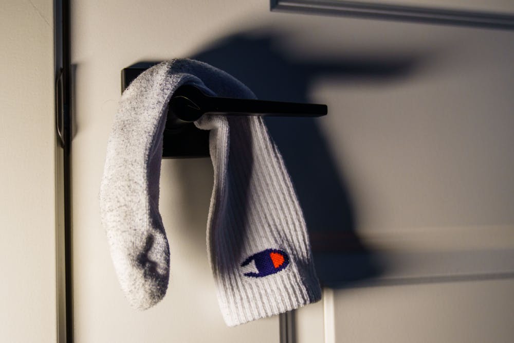 A sock is hung on a door handle, a nonverbal sign for privacy in many situations, expecially dorm rooms.