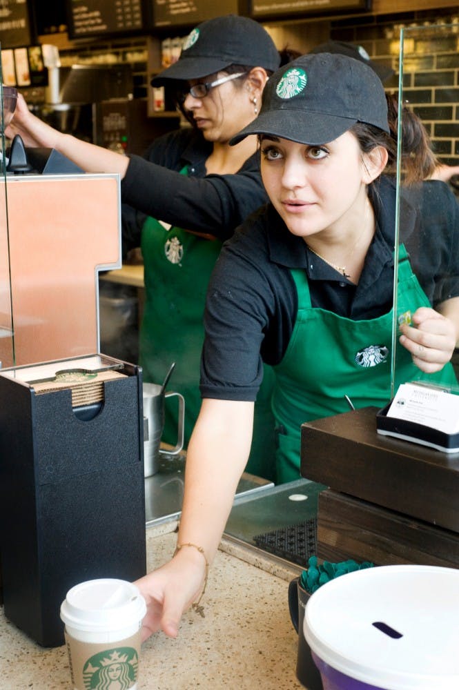 Medical technology senior Preety Otal, left, prepares drinks while packaging sophomore Samantha Savich delivers a beverage to a customer Thursday afternoon at Wells Hall. Starbucks Coffee opened the location its at Wells Hall in September 2011. Justin Wan/The State News