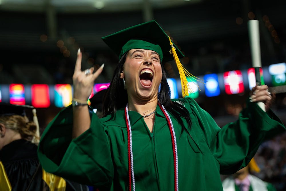 A graduate celebrates after receiving her diploma at the Breslin Center on May 3, 2025.
