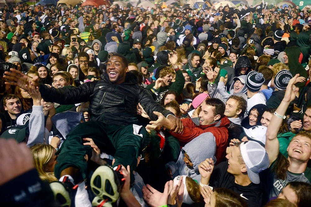<p>Senior guard/forward Branden Dawson crowd surfs Oct. 17, 2014, during the Izzone Campout at Munn Field. Hundreds of students battled the cold and rain to sleep outdoors overnight in hopes of getting lower bowl seating. Julia Nagy/The State News</p>