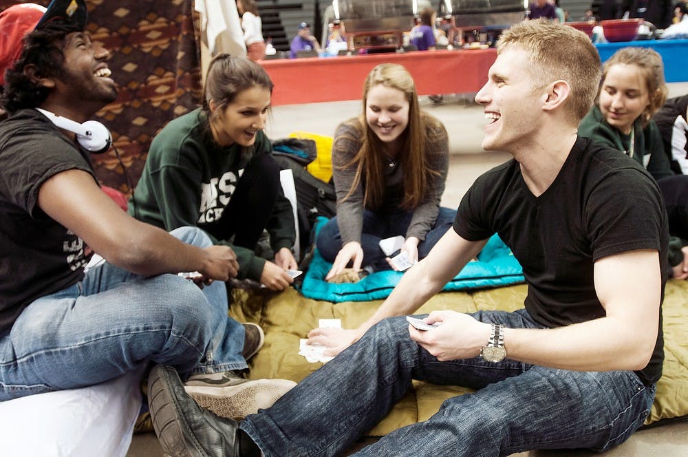 <p>Then-packaging junior Matt Somaiah, left, and then-packaging senior Nick Salic play cards during Relay for Life March 28, 2014, at Breslin Center. The group entertained themselves during the 12-hour fundraiser by playing cards. State News File Photo</p>