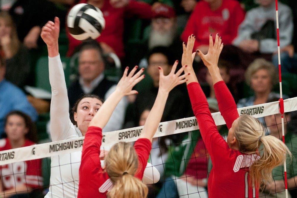 	<p>Senior outside hitter Lauren Wicinski hits the ball as Ohio State middle blocker Taylor Sandbothe and outside hitter Kaitlyn Leary, 11, try to block Nov. 1, 2013, during the game against Ohio State at Jenison Field House. The Spartans defeated the Buckeyes, 3-0. Julia Nagy/The State News </p>
