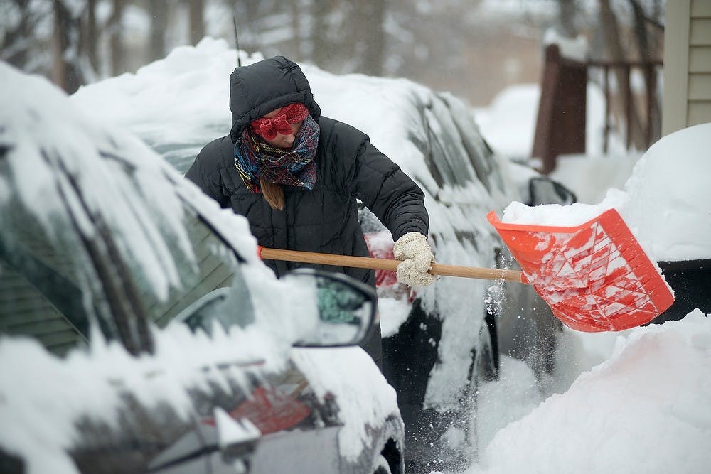 	<p>Chemistry senior Lucy Johnson helps her friends shovel their driveways Jan. 6, 2014, at her house on Charles Street. East Lansing declared a weather emergency, asking residents to not travel public streets unless necessary. Julia Nagy/The State News</p>