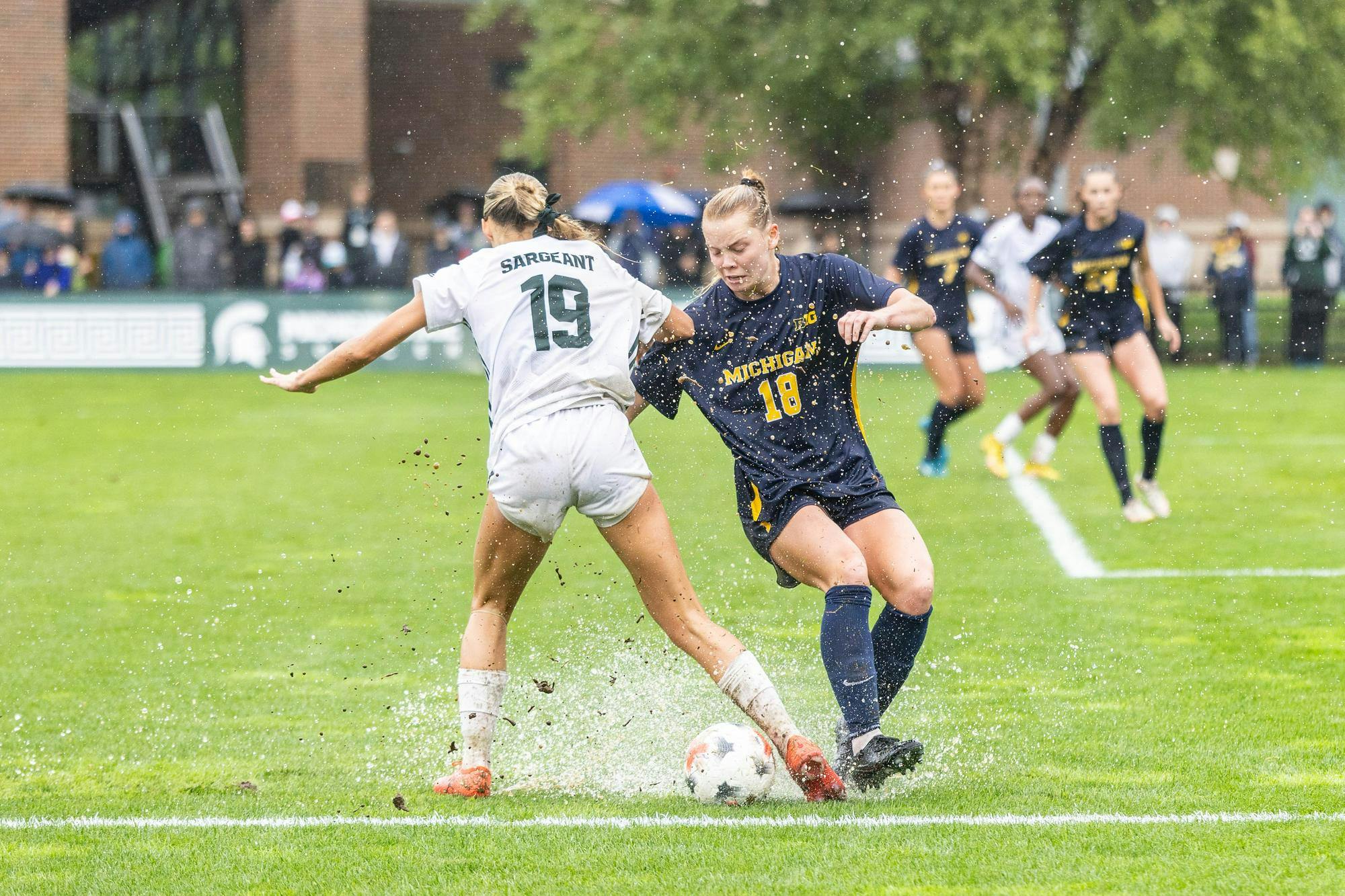 <p>Muddy conditions severely impact the play between MSU senior midfielder Emerson Sargeant (19) and Michigan freshman defender Torah Betteridge (18) as rain continues to pour down at DeMartin Stadium in East Lansing, Mich., on Sept. 20, 2026.</p>