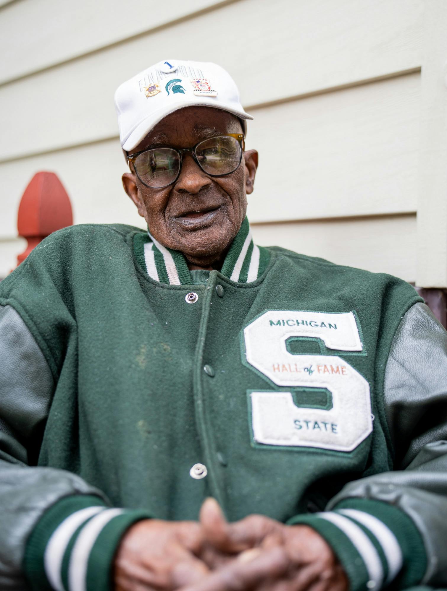 Homecoming Grand Marshal James E. Bibbs sits outside of his home in East Lansing, MI on Oct. 13, 2022. Bibbs was the first Black head coach at Michigan State University when he started in 1968, as well as the first Black head track coach in the Big Ten. 

As a coach he helped his athletes, some of whom became Olympians, toward 52 Big Ten titles and 26 All-American letters. As a runner he tied Jesse Owen's world record in the 60-yard dash in 1951.