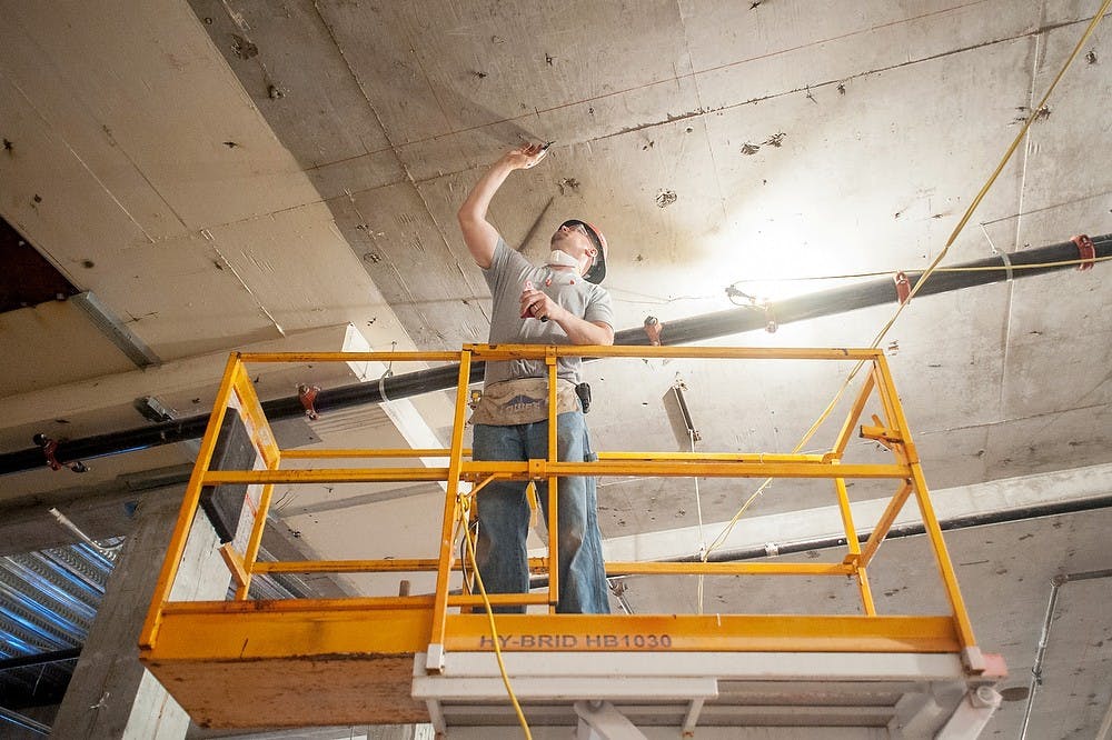 	<p>Construction worker Blake Clark, of Grand Ledge, Mich., marks the ceiling before drilling a hole June 19, 2013, at the future site for Jackson National Life, 333 E. Grand River Ave. Construction is currently underway to transform the old site of Barnes &amp; Noble, which was closed in January 2012. Justin Wan/The State News</p>