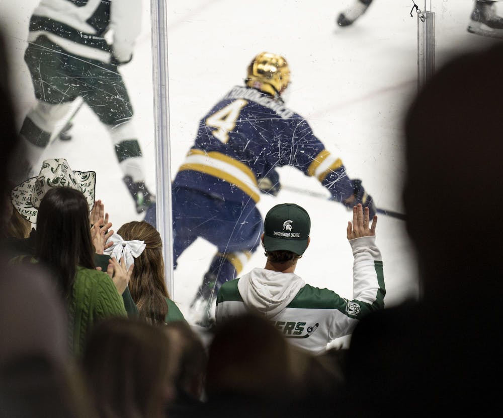 <p>An MSU fan bangs on the glass during the MSU vs. Notre Dame men’s hockey game in the Munn Ice Arena on Nov. 16, 2024.</p>