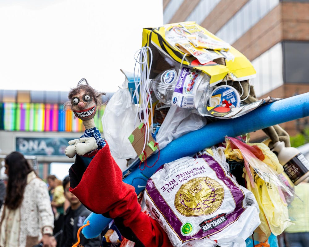 <p>A person dressed up in a costume of random items holds a doll at the East Lansing Art Festival in East Lansing, Mich., on May 16, 2026.</p>