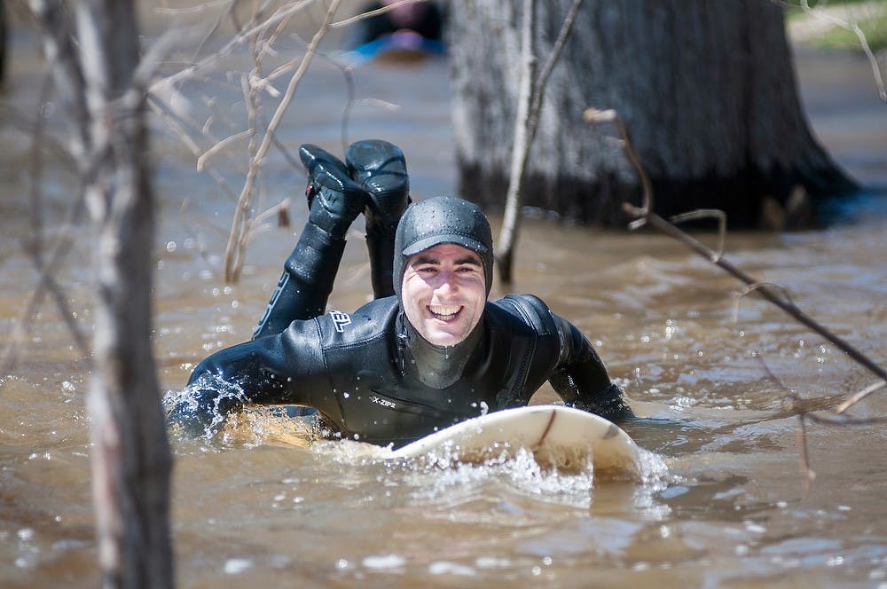 	<p>East Lansing resident Remi Hamel paddles on his surf board, April 22, 2013, in the Red Cedar River behind the Hannah Administration Building. Hamel grew up in Santa Cruz, Calif., where he learned how to surf. </p>